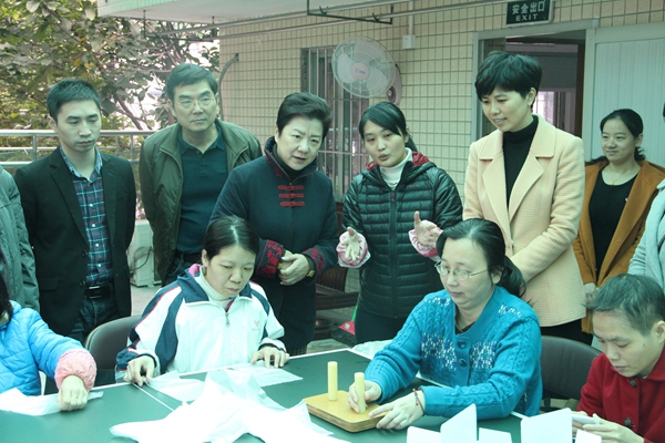 图为检查评估组视察天河区残疾人精综服务中心