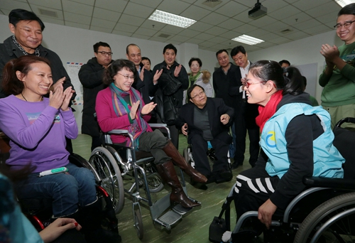 图为海迪主席调研脊髓损伤学员康复训练情况,这是学员在进行轮椅使用训练