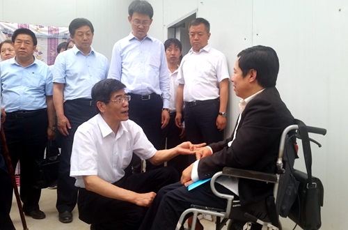 图为鲁勇一行在残疾人就业扶贫基地与残疾人代表交流