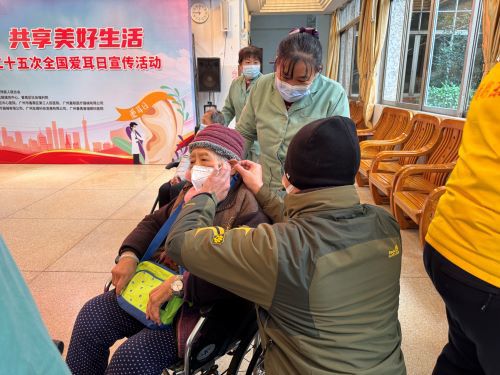 助听器定点机构工作人员为老年人检查耳道