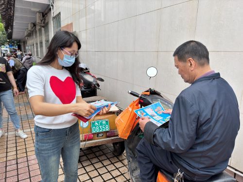 工作人员向车主派发交通安全知识宣传小册子