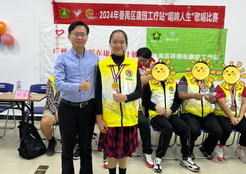 广州市志愿者行动指导中心党支部书记、主任马发腾为获得歌唱比赛一等奖的残疾人选手小文进行颁奖